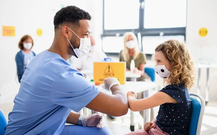 Video thumbnail of a doctor and child wearing masks, using elbow touches in place of a handshake.
