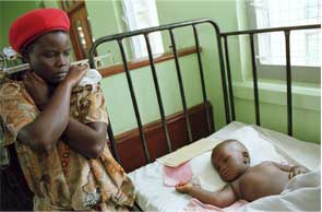 A mother next to her child in a hospital bed with measles.